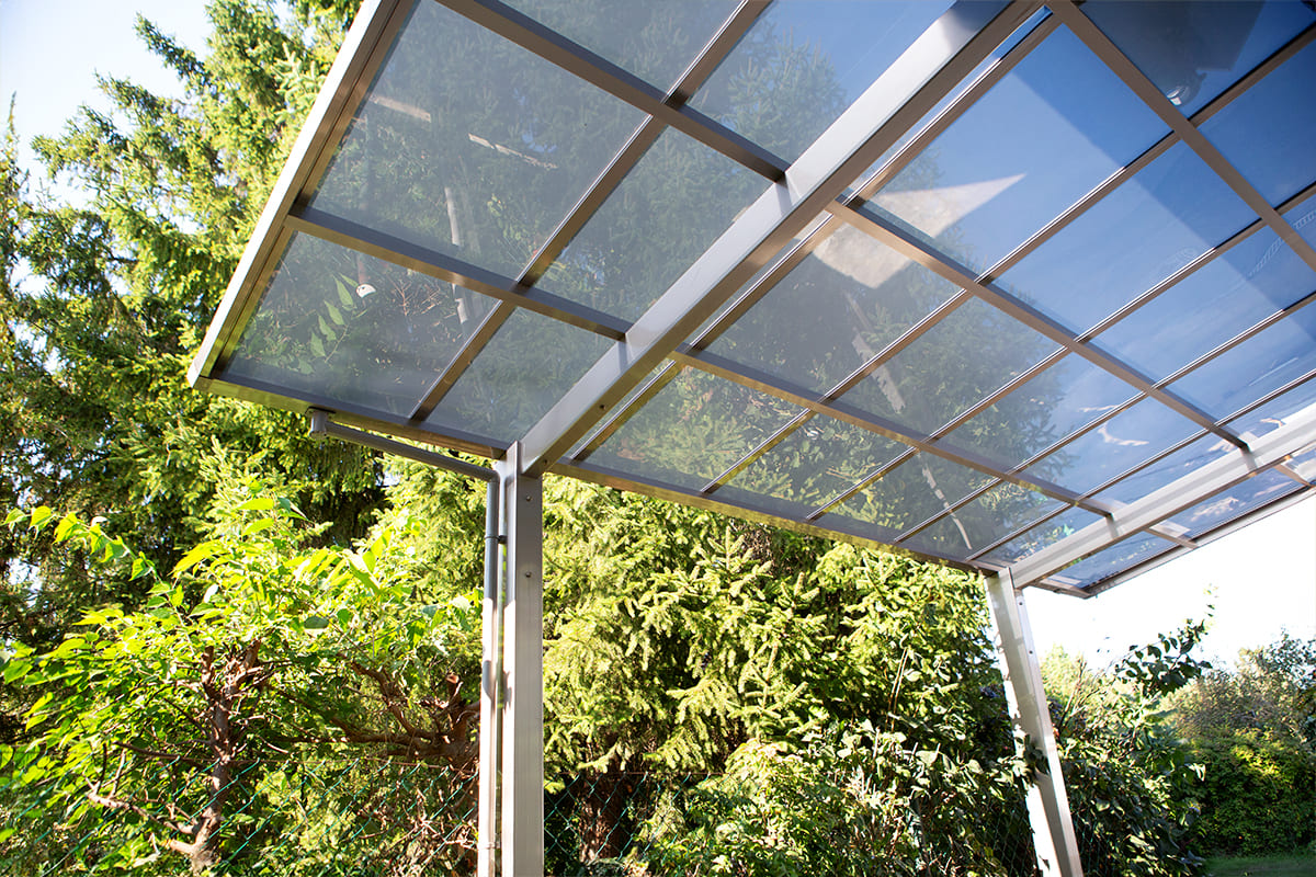 Előregyártott kocsibeálló alumínium vázzal és polikarbonát tetővel.