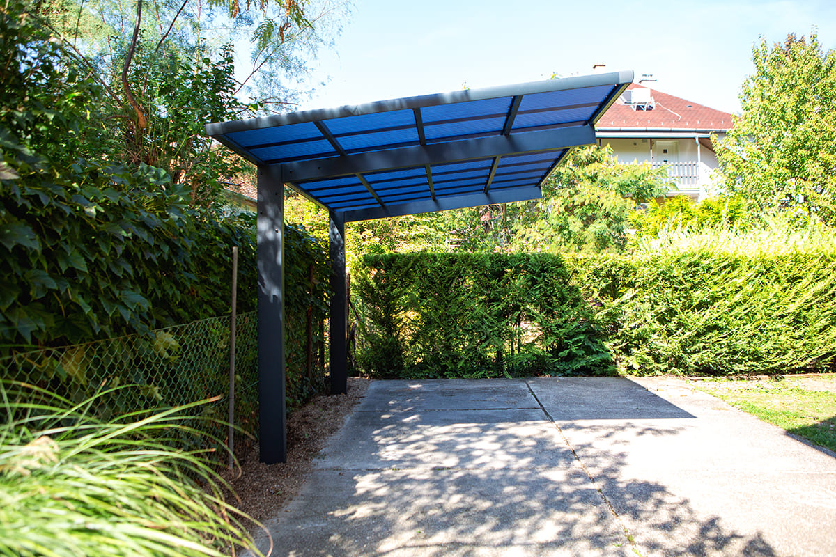 Előregyártott kocsibeálló alumínium vázzal és polikarbonát tetővel.