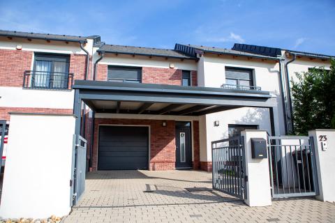 Szendvicspanel fedésű kocsibeálló, antracit színű rétegragasztott fa szerkezettel