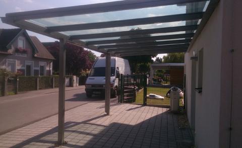 Kocsibeálló bécsben porfestett acél szerkezettel és ragasztott biztonsági üveg tetővel