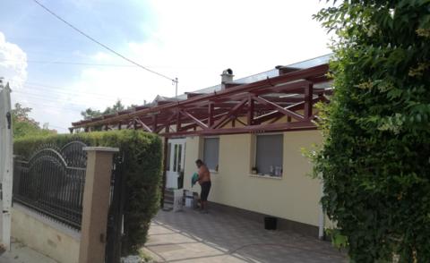 Porfestett acél tartószerkezet rácsostartóval + ragasztott biztonsági üveg fedéssel készült autóbeálló