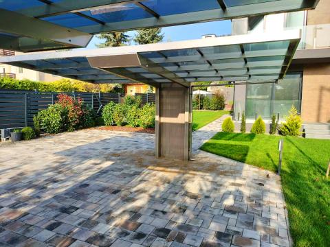 Elegáns vonalvezetésű, alumínium szerkezetű XIMAX NEO dupla autóbeálló. Fedése füst színű tömör polikarbonát