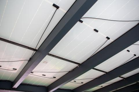 Napelemekkel fedett, extra hosszú, négy állásos kocsibeálló rétegragasztott fa szerkezettel.